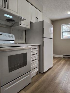 Brantford apartment for rent - A kitchen with a white oven and refrigerator.