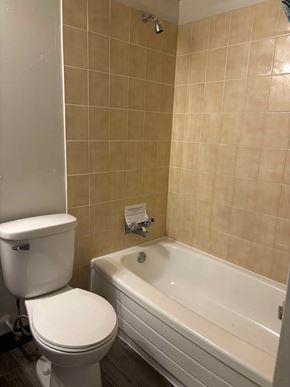 Halifax apartment for rent - A white toilet sits next to a bathtub in a bathroom.