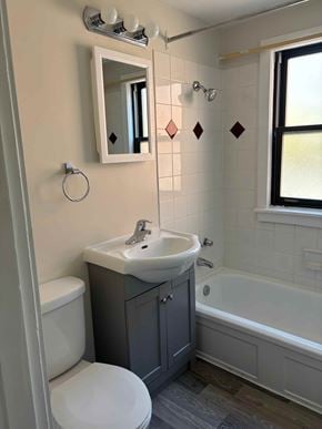 Halifax apartment for rent - A bathroom with a white toilet, a sink, and a bathtub.