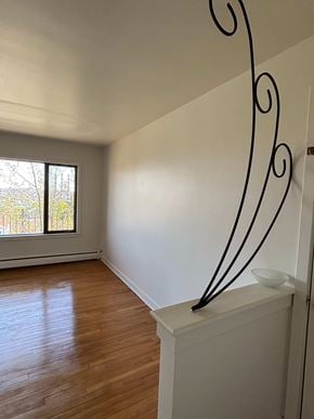 Halifax apartment for rent - A room with a wooden floor and a metal railing.