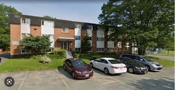 Halifax apartment for rent - A parking lot with cars and a building in the background.