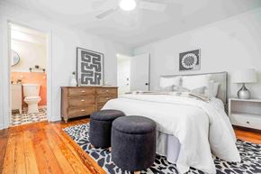 Atlanta apartment for rent - A bedroom with a white bed and a wooden floor.