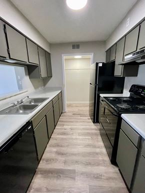 Baton Rouge apartment for rent - an empty kitchen with black appliances and white counters