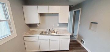 Gary house for rent - a kitchen with a sink and white cabinets