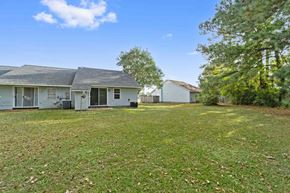 Havelock house for rent - A house with a white garage door is surrounded by a grassy yard.
