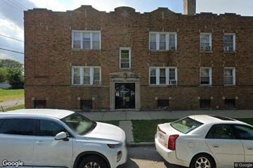 Chicago apartment for rent - Two white cars parked in front of a brick building.