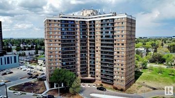 Edmonton apartment for rent - A large, multi-story building with a parking lot in front.