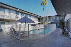 Los Angeles apartment for rent - A pool area with a blue umbrella and a palm tree.