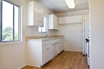 Los Angeles apartment for rent - A kitchen with white cabinets and a wooden floor.