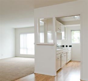Los Angeles apartment for rent - A white kitchen with a window and a door leading to another room.
