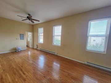 Philadelphia apartment for rent - Empty room with wood flooring and a ceiling fan.