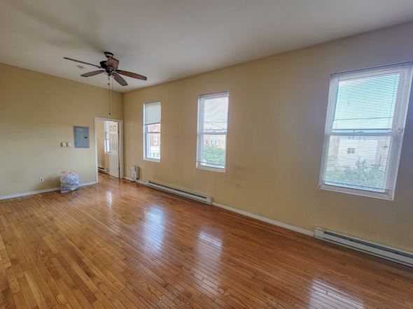 Philadelphia apartment for rent - Empty room with wood flooring and a ceiling fan.