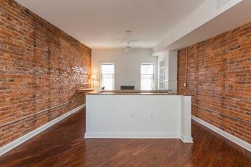 Philadelphia house for rent - A room with a brick wall and wooden flooring.
