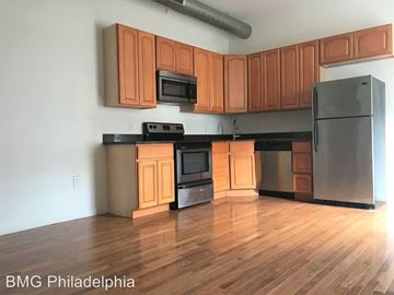Philadelphia apartment for rent - A kitchen with wooden cabinets and a black refrigerator.
