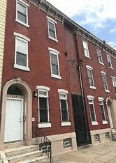 Philadelphia apartment for rent - A red brick building with a black door and windows.