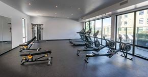 Saskatoon apartment for rent - A gym with a row of treadmills and a row of weight machines.