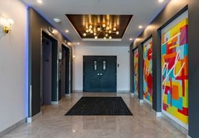Saskatoon apartment for rent - A hallway with a black door and a chandelier.