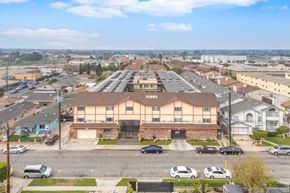 Hawthorne apartment for rent - A parking lot with cars and a building with a sign that says "Torrance".