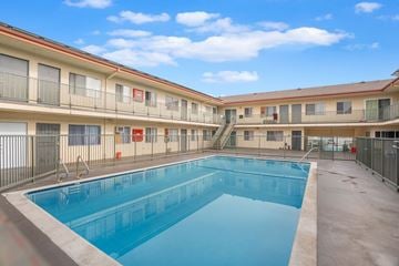 Hawthorne apartment for rent - A swimming pool is located in the middle of a courtyard surrounded by apartment buildings.
