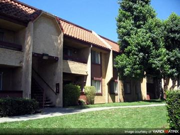 Azusa apartment for rent - A building with a red tile roof and a green lawn in front.