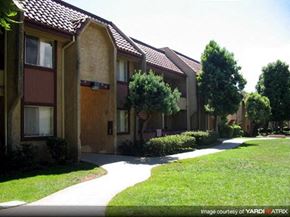 Azusa apartment for rent - A long white pathway leads to a building with a brown door.