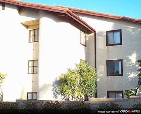 Costa Mesa apartment for rent - a white building with a red roof and a tree