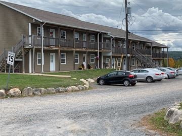 Kentville apartment for rent - A black car is parked in front of a two-story apartment building.