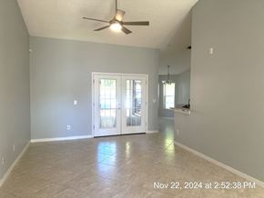 Orlando house for rent - A room with a ceiling fan and a door leading to a balcony.