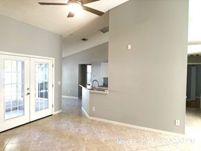 Orlando house for rent - A room with a ceiling fan and a kitchen area with a sink.