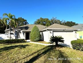Orlando house for rent - A house with a white exterior and a green lawn in front.