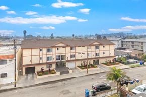 Hawthorne apartment for rent - A building with a red roof and a parking lot in front.