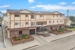 Hawthorne apartment for rent - A large building with a red brick wall in front.