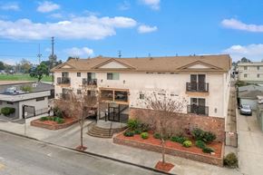 Hawthorne apartment for rent - A two-story building with a brown roof and a brick wall in front.