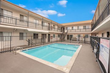Hawthorne apartment for rent - A swimming pool is surrounded by a black fence in a courtyard.
