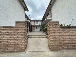 Vista apartment for rent - A courtyard with a staircase leading to a building.