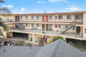 Hawthorne apartment for rent - Apartment complex with a grey roof and a balcony.