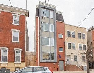 Philadelphia apartment for rent - a tall brick building with a tall glass window