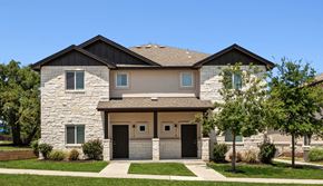 Leander apartment for rent - A house with a stone facade and a black roof.