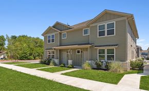 Hutto apartment for rent - A two-story house with a gray siding exterior and a brown roof.
