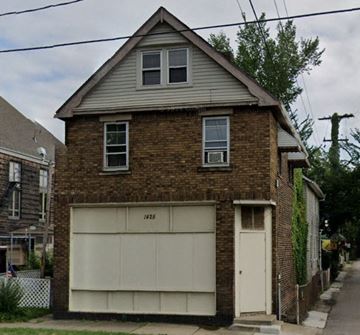 Cleveland apartment for rent - A two-story brick house with a garage door that says 1925 on it.