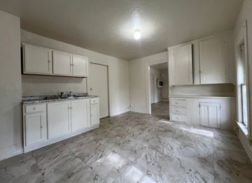 Cleveland apartment for rent - A kitchen with white cabinets and marble flooring.