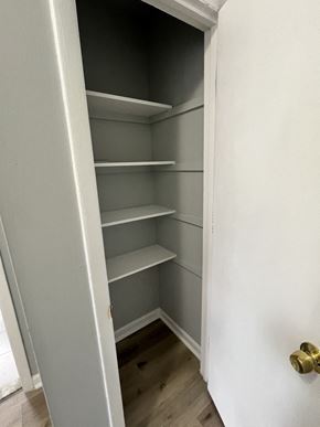 Washington apartment for rent - A white door with a gold handle is open to reveal a white shelving unit.