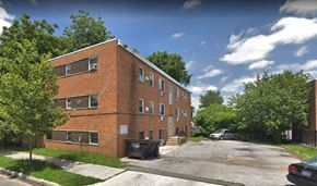 Washington apartment for rent - A red brick building with a parking lot in front.