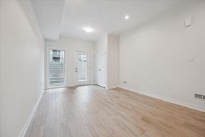 Kitchener apartment for rent - A spacious room with light wood flooring and white walls.