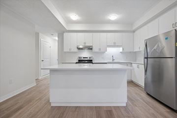 Kitchener apartment for rent - A white kitchen with a refrigerator on the right.