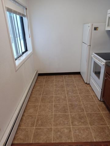 Wasilla apartment for rent - A kitchen with a white refrigerator and brown tiled floor.