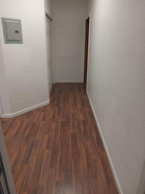 Wasilla apartment for rent - A hallway with wood flooring and white walls.