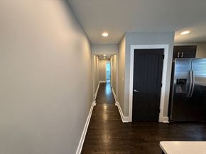 Charlotte house for rent - A long hallway with a black door on the right.