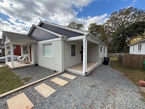 Charlotte house for rent - A house with a gravel driveway and a covered patio.