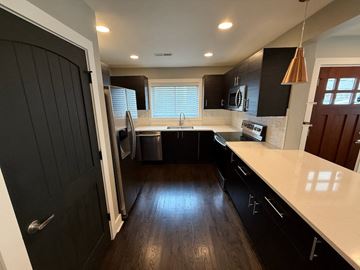 Charlotte house for rent - A modern kitchen with black cabinets and a white countertop.